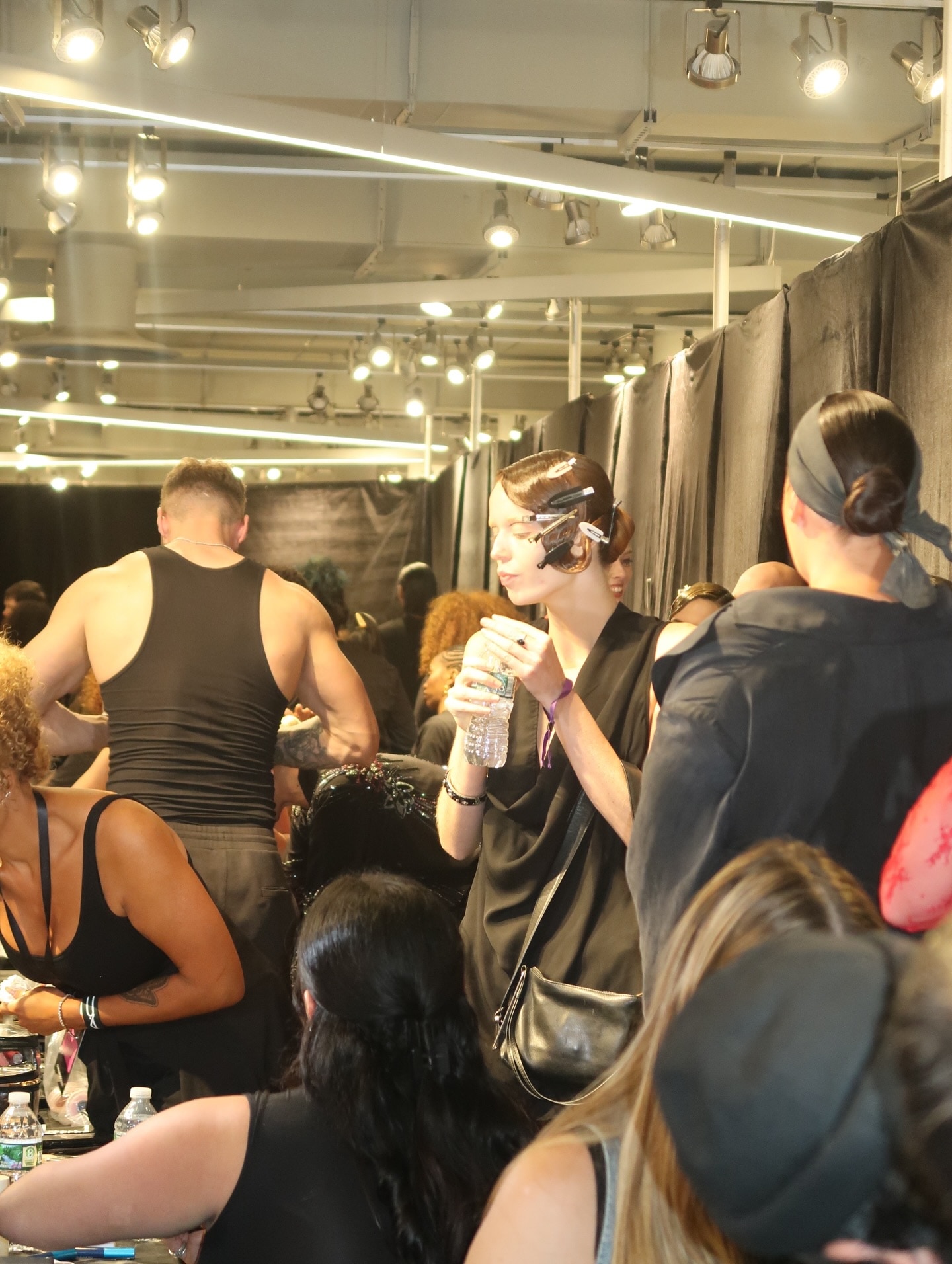 Models and crew waiting in a backstage crowd