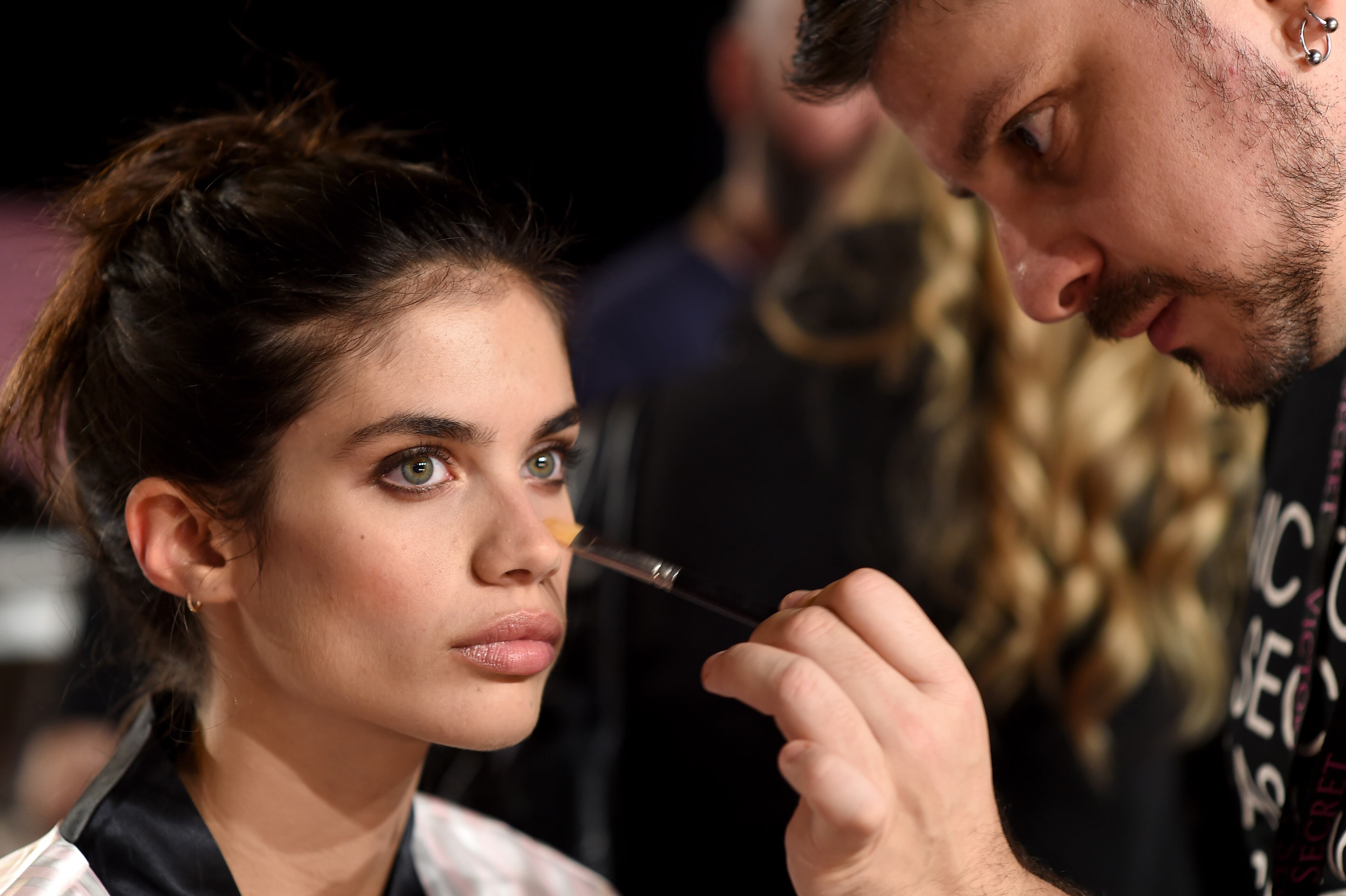 Close-up backstage makeup detail before a runway show